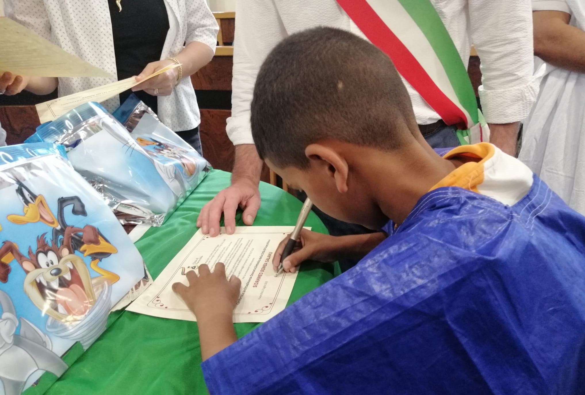 Un bambino Saharawi firma il documento per la cittadinanza (Fonte foto Comune di Fucecchio)